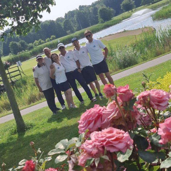 Seniorenmannschaft - Golfergruppe mit Rosen im Vordergrund, See und Wasserfontaine im Hintergrund