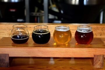 Vier verschiedene Biere im Glas in einem Brett
