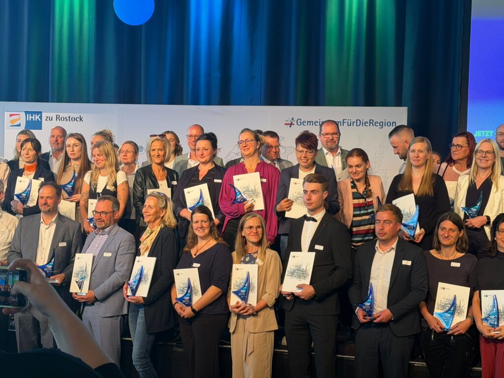 Menschen bei der Auszeichnung IHK Top Ausbildungsbetrieb 2026 halten Urkunden in den Händen