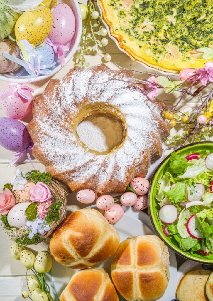 Osterkuchenkranz, Broetchen, Ostereier, Salat und Rührei auf einem Tisch